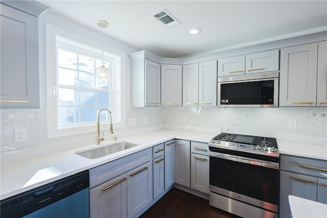 kitchen with sink, hanging light fixtures, tasteful backsplash, dark hardwood / wood-style flooring, and appliances with stainless steel finishes