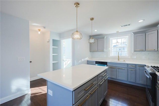 kitchen featuring sink, a center island, dark hardwood / wood-style floors, and appliances with stainless steel finishes