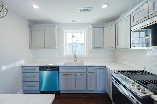 kitchen with sink, dark hardwood / wood-style floors, tasteful backsplash, decorative light fixtures, and stainless steel appliances