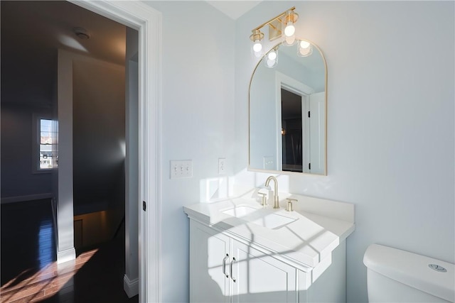 bathroom featuring wood-type flooring, toilet, and sink