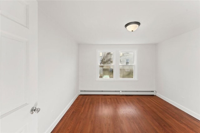 spare room with a baseboard heating unit and dark wood-type flooring