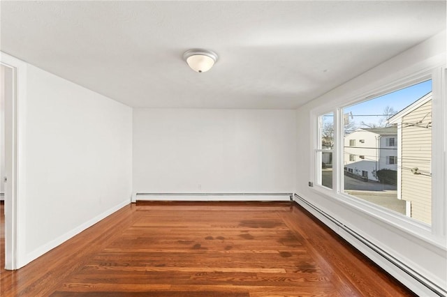 unfurnished room with a baseboard radiator and hardwood / wood-style flooring