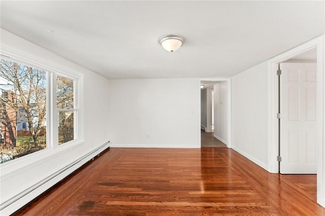 unfurnished room with wood-type flooring and a baseboard heating unit