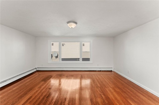 empty room with a baseboard radiator and hardwood / wood-style flooring