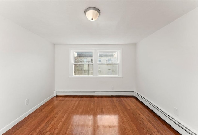 unfurnished room with hardwood / wood-style floors and baseboard heating