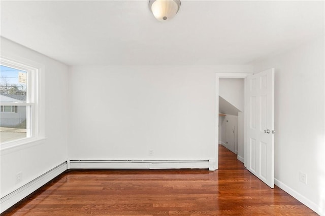 empty room featuring a baseboard radiator and dark wood-type flooring