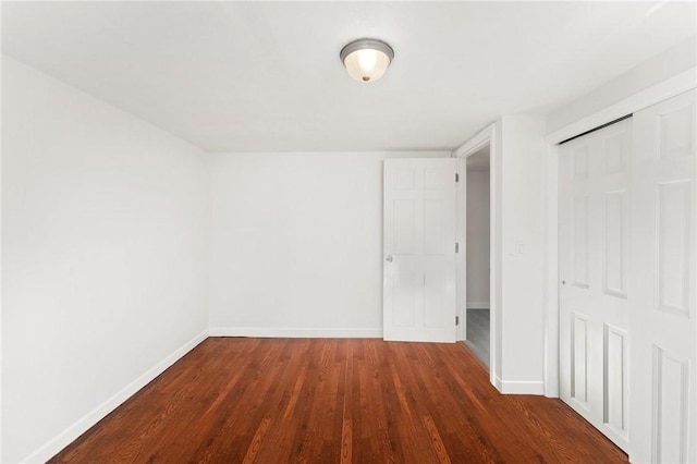 unfurnished room with dark wood-type flooring