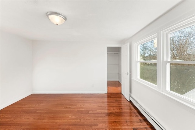 spare room with dark hardwood / wood-style floors and a baseboard radiator