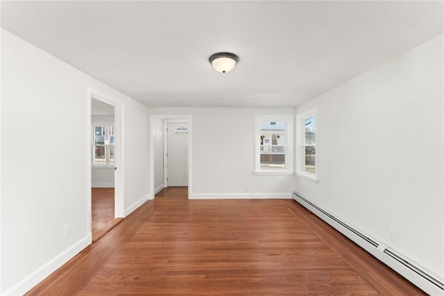 spare room featuring hardwood / wood-style floors and a baseboard heating unit