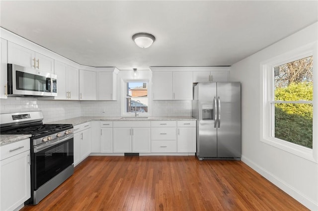 kitchen featuring stainless steel appliances, white cabinetry, dark wood-type flooring, and sink