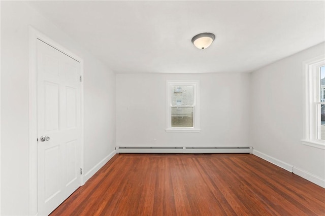 unfurnished room featuring a baseboard radiator and dark hardwood / wood-style floors