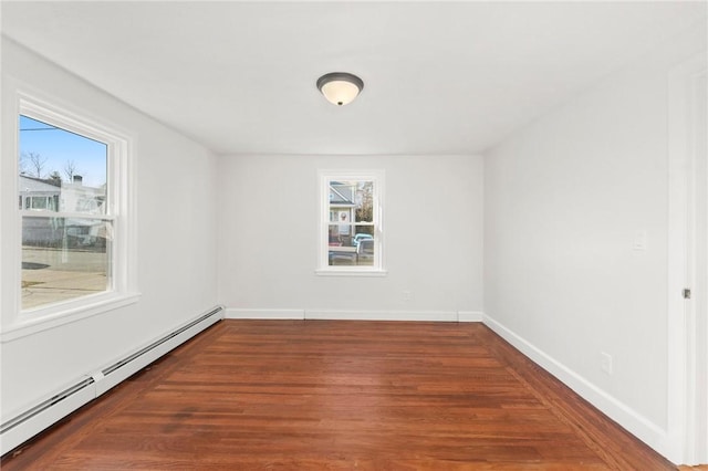 unfurnished room with plenty of natural light, dark hardwood / wood-style floors, and a baseboard heating unit