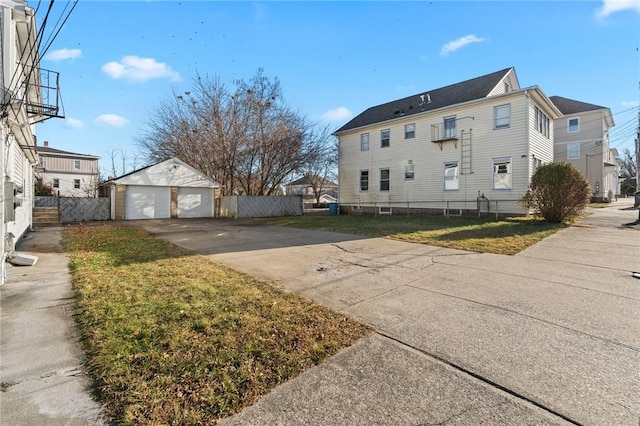 view of side of property with a garage, an outdoor structure, and a yard