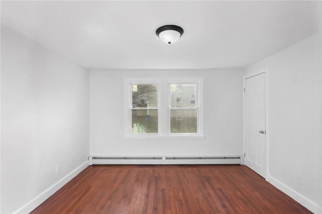 unfurnished room with dark hardwood / wood-style floors and a baseboard heating unit