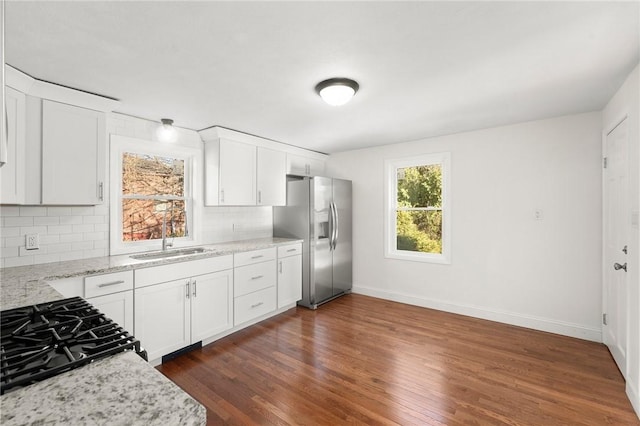 kitchen featuring white cabinets, sink, dark hardwood / wood-style floors, appliances with stainless steel finishes, and light stone counters