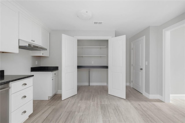 interior space with light hardwood / wood-style floors and white cabinetry