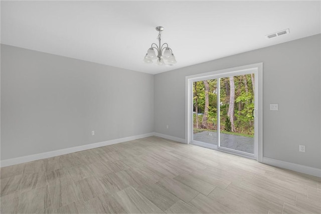 unfurnished room featuring light hardwood / wood-style flooring and an inviting chandelier