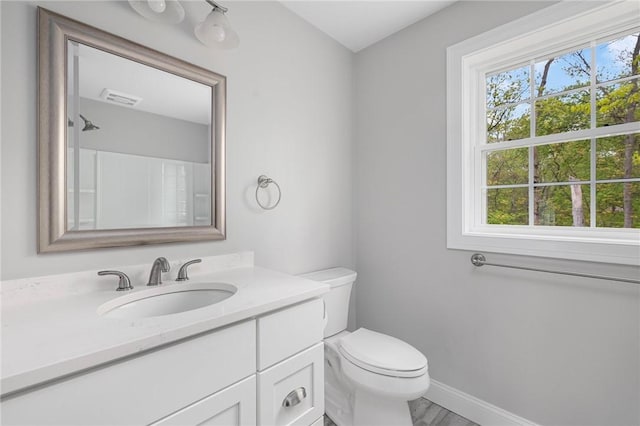 bathroom featuring vanity, wood-type flooring, and toilet