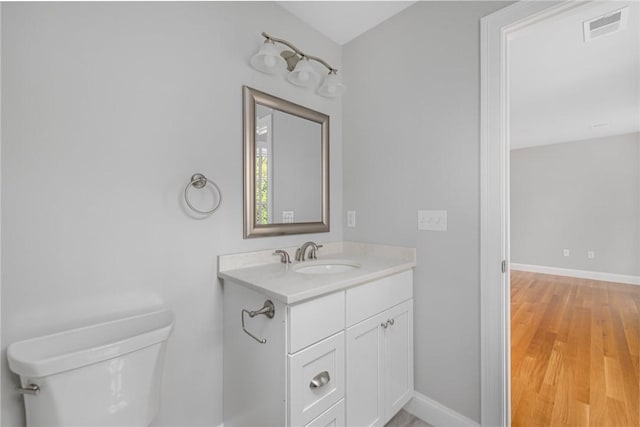 bathroom featuring hardwood / wood-style floors, vanity, and toilet