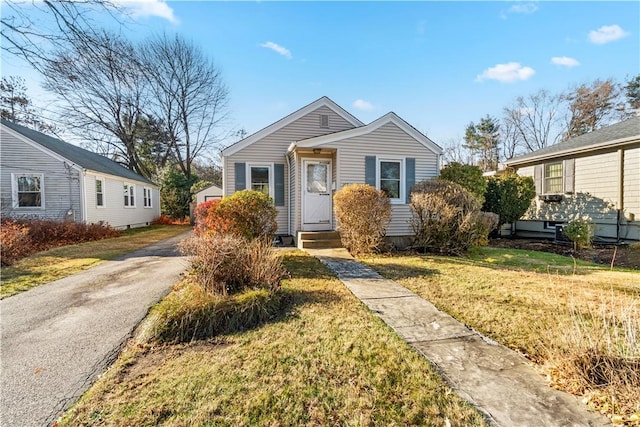 bungalow-style home with a front yard