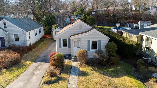 view of front of home with cooling unit and a front yard