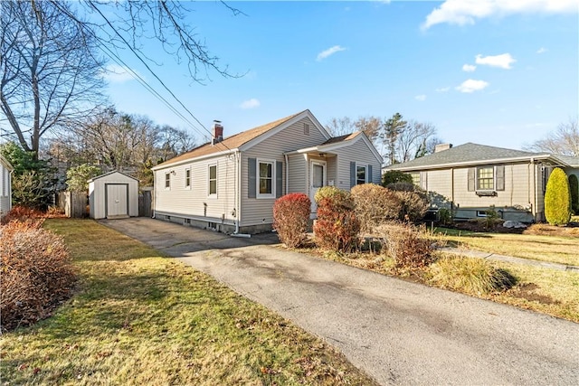 view of front of house featuring a storage unit and a front yard