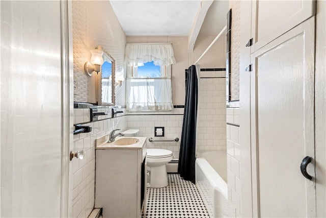 full bathroom with vanity, toilet, tile walls, and shower / tub combo with curtain