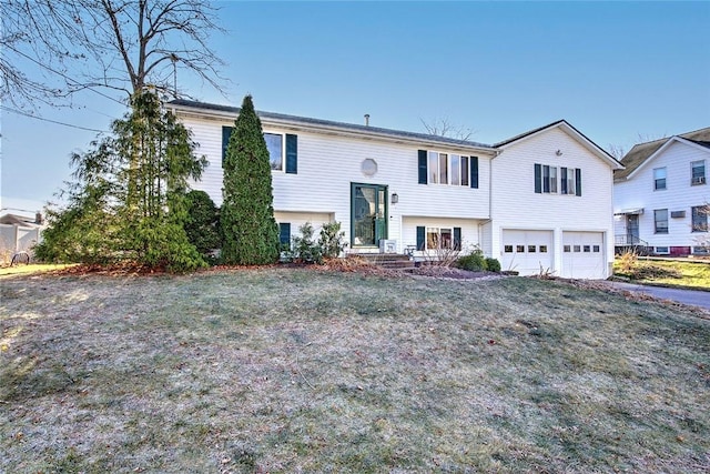 split foyer home featuring a front yard and a garage