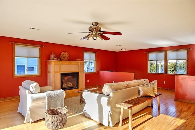 living room with plenty of natural light, light hardwood / wood-style floors, and ceiling fan