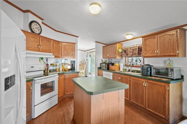 kitchen with sink, dark hardwood / wood-style flooring, white appliances, a kitchen island, and ornamental molding