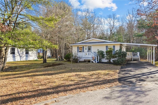 view of front of home with a carport and a front lawn