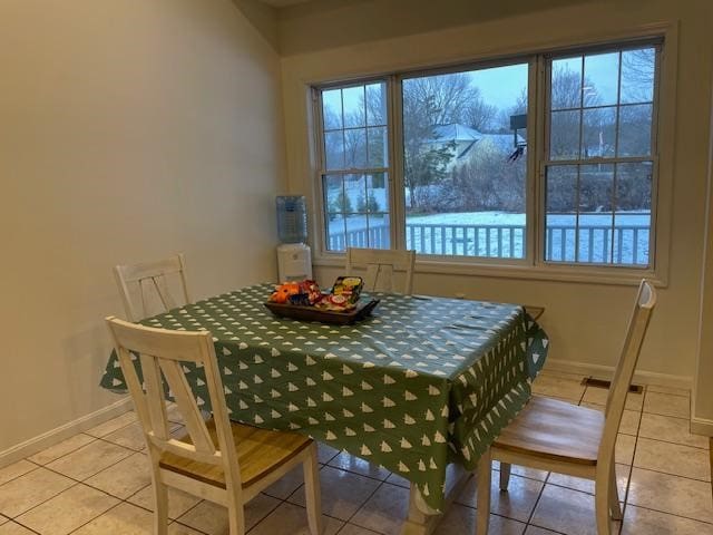 tiled dining space featuring a healthy amount of sunlight