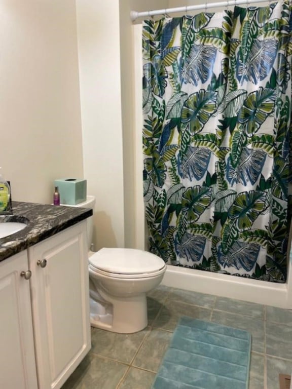 bathroom featuring tile patterned floors, walk in shower, vanity, and toilet