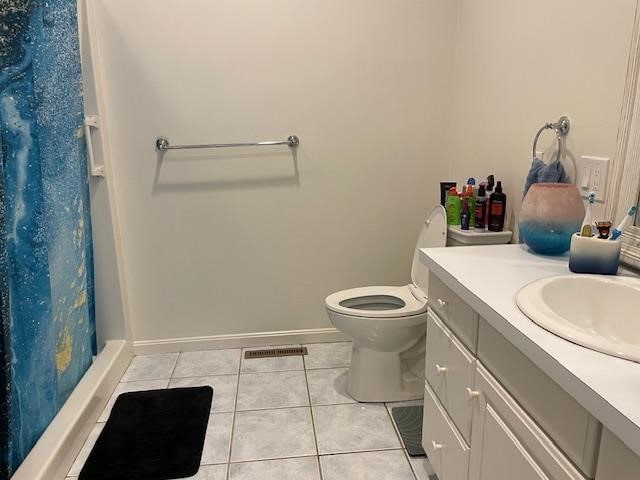 bathroom featuring toilet, vanity, tile patterned floors, and curtained shower