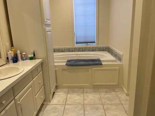 bathroom with a tub to relax in, tile patterned flooring, and vanity