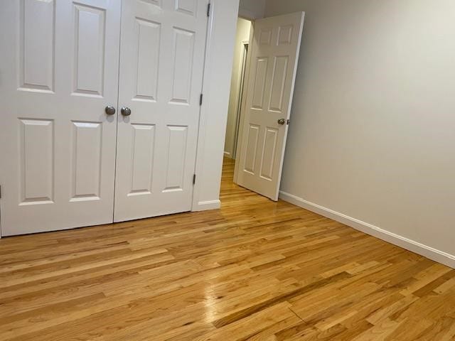 unfurnished bedroom featuring a closet and light hardwood / wood-style floors