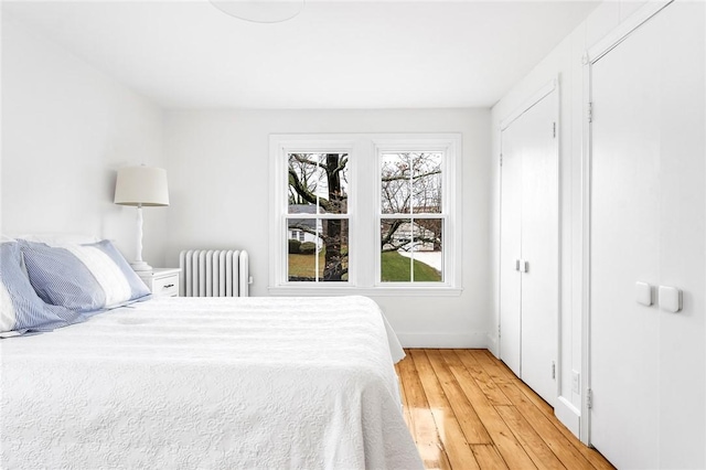 bedroom with radiator heating unit and hardwood / wood-style floors