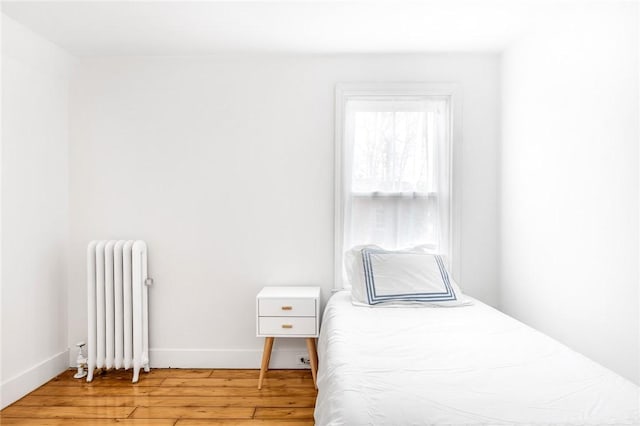 bedroom featuring light hardwood / wood-style flooring and radiator