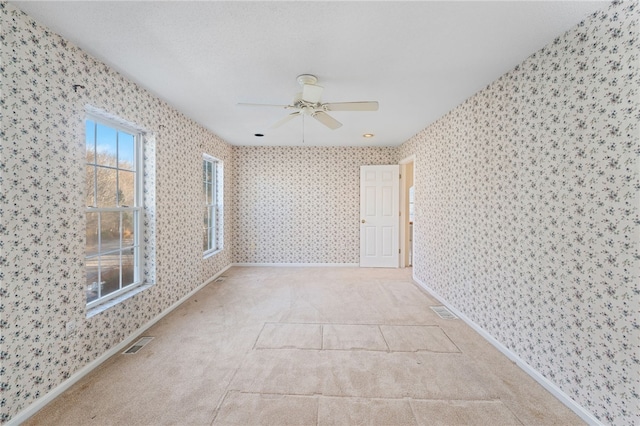 carpeted spare room featuring ceiling fan