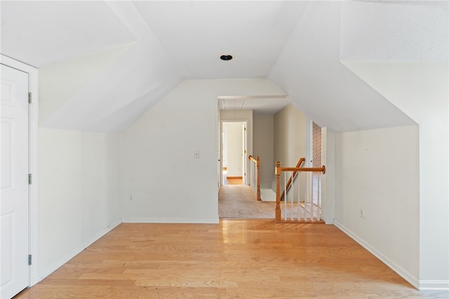 additional living space featuring lofted ceiling and light wood-type flooring