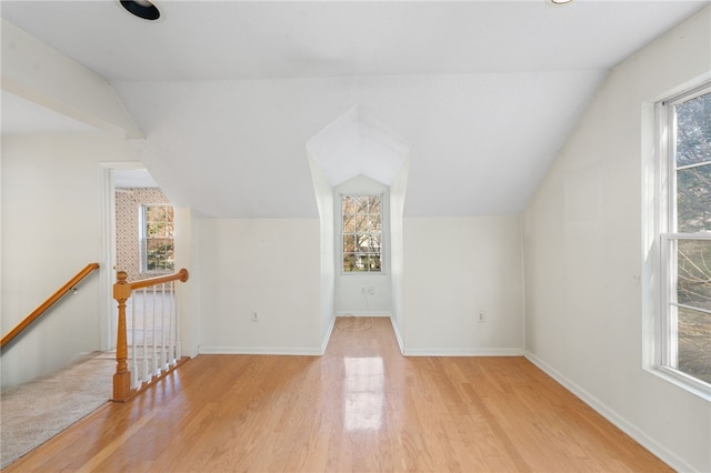 additional living space with light wood-type flooring and lofted ceiling