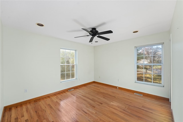 unfurnished room with a wealth of natural light, ceiling fan, and hardwood / wood-style flooring