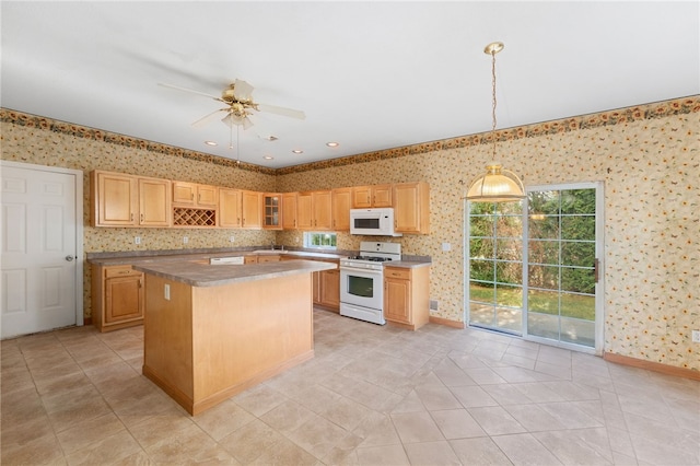 kitchen featuring light brown cabinetry, white appliances, ceiling fan, decorative light fixtures, and a kitchen island