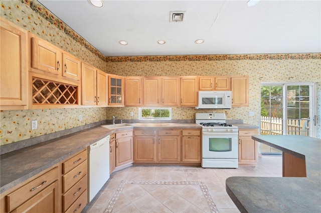 kitchen featuring light tile patterned flooring, white appliances, sink, and light brown cabinetry