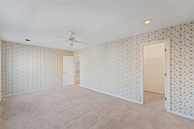 carpeted spare room with ceiling fan and a textured ceiling