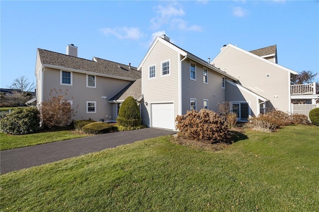 view of side of property featuring a lawn and a garage