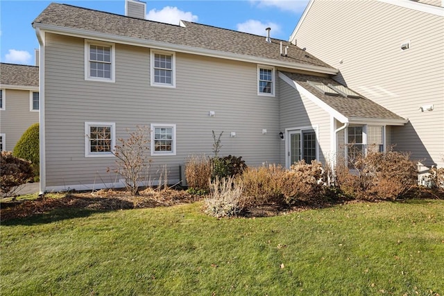 rear view of property with a lawn