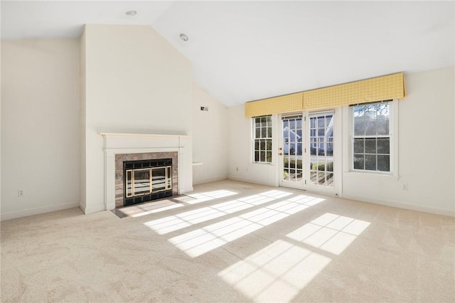 unfurnished living room featuring lofted ceiling, a fireplace, and light carpet