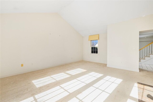 interior space featuring light colored carpet and vaulted ceiling