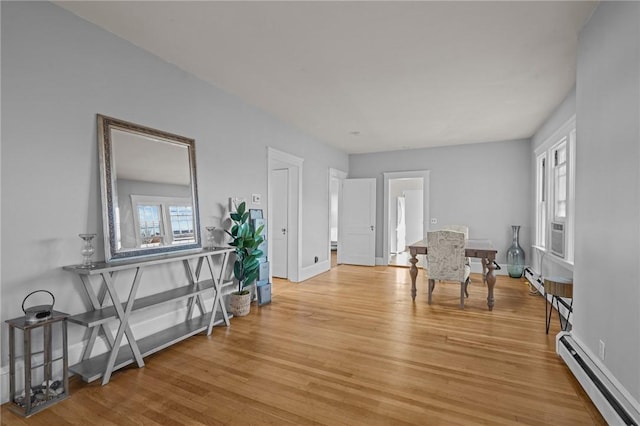 living area featuring light wood-type flooring and a baseboard heating unit